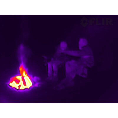 Termovízny záber dvoch osôb pri ohni v noci, zhotovený termokamerou FLIR Scout TK.