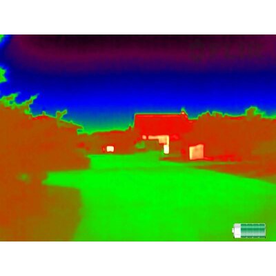 Termovízny obraz z kamery FLIR SCOUT TK zobrazujúci krajinu s budovami a vegetáciou v rôznych farbách tepelného spektra.