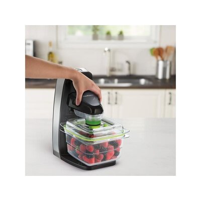 Vákuová balička potravín FoodSaver FFS010X-01 používaná na vákuovanie dózy s čerstvými jahodami na kuchynskom pulte.