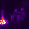 Termovízny záber dvoch osôb pri ohni v noci, zhotovený termokamerou FLIR Scout TK.