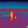 Termovízny pohľad s FLIR Scout TK zobrazuje osobu a psa v prírode.